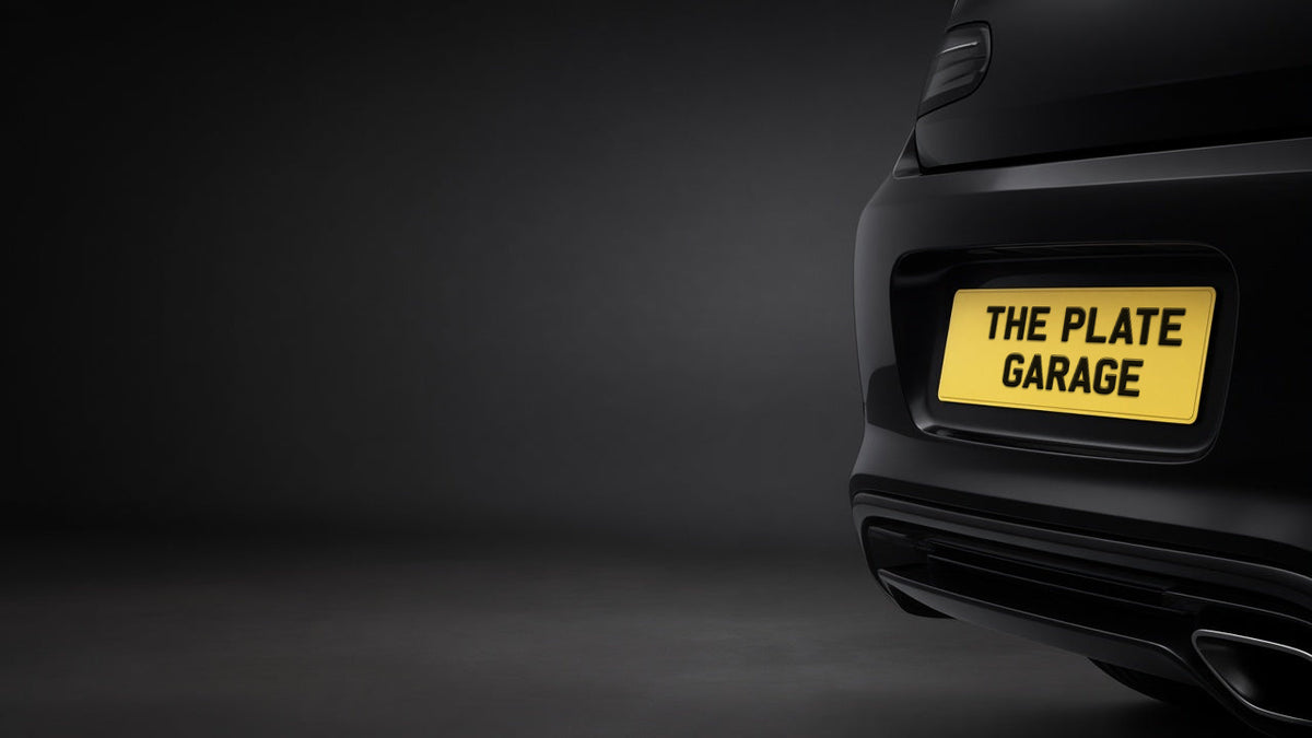 Rear of a black car with a yellow The Plate Garage number plate in a dark studio